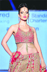 Kangana Ranaut walks the ramp to display designer Azeem Khan's creation during a fashion show in Mumbai recently.