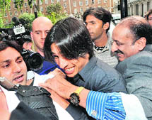 Mohammad Aamir (centre) and Mohammad Asif (rear) arrive at the Pakistan High Commission in London on Thursday.