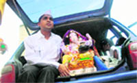 A man carries an idol of Lord Ganesha in his car, in Mumbai 