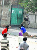 Protesters throw stones at a cop in Srinagar