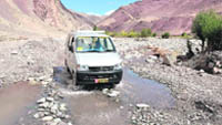 A car manoeuvres its way on the Leh-Manali highway near Upshi village, 50 km from Leh