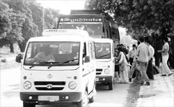 Chandigarh-bound passengers alight from a private bus before boarding maxi cabs at Mohali bus stand on Thursday.