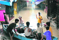 Local residents use a boat at the Tibetan market in New Delhi on Wednesday. The river water level has breached the danger mark again this monsoon season. 