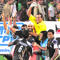 Indian players celebrate their victory over England in mens hockey semifinal match in New Delhi on Tuesday. India won 5-4 on penalties after the scores were tied 3-3 at the end of extra time.