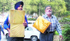 Two others with gifts walk towards the Mini Secretariat in Ludhiana.
