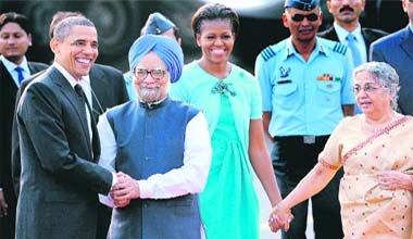 US President Barack Obama and Indian Prime Minister Manmohan Singh shake hands as First Lady Michelle Obama and Gursharan Kaur look on at the New Delhi airport on Sunday