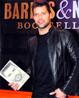 Singer Ricky Martin poses with a Spanish language copy of his autobiography Me before a book signing in Los Angeles November 9, 2010.