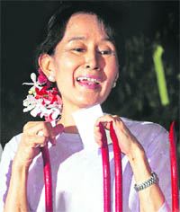  Aung San Suu Kyi talks to her supporters at the gate of her home in Yangon on Saturday.