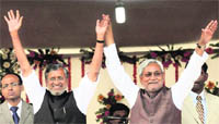Bihar Chief Minister Nitish Kumar and Cabinet minister Sushil Kumar Modi wave after their swearing-in ceremony at Gandhi Maidan in Patna 