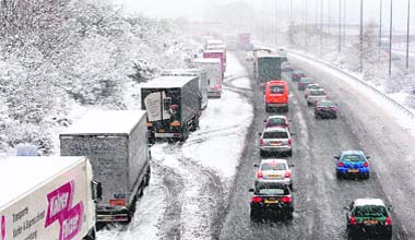 Lorries parked on a motorway in southern England. Large areas of Britain were brought to a halt as freezing weather tightened its grip on the country and Europe