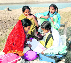  A girl does her homework on a makeshift bed on the banks of the Sutlej, in Ludhiana, on Saturday. 