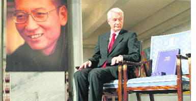 Chairman of Nobel Committee Thorbjoern Jagland looks at the reserved vacant chair of Nobel laureate Liu Xiaobo ( portrait at left ), on which Jagland placed the Nobel Peace Prize diploma and gold medal during the ceremony for the Nobel Laureate and dissident Liu Xiaobo at the city hall in Oslo