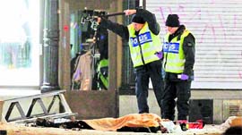 Forensic experts examine the remains of a suspected suicide bomber in Stockholm on Saturday.
