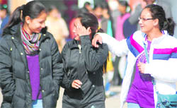 Girls enjoy a brief period of sunshine on the otherwise foggy Wednesday in the city