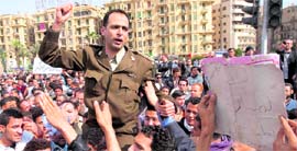 An Egyptian army officer shouts slogans while being carried by demonstrators in Cairo on Sunday.
