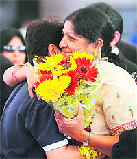 Relatives greet a passenger on her arrival from Cairo at the Mumbai airport on Monday. 