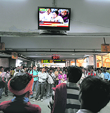 People gather to watch the broadcast of Railway Budget speech in Kolkata. 