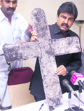 In this file photo of a press conference in 2005, Bhatti shows a cross, which was burned during an attack on a church in central Punjab province.