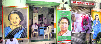 A Trinamool worker pastes posters ahead @@of the poll in West Bengal, in Kolkata on Wednesday.  PTI