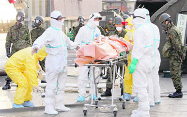 A person who is believed to be have been contaminated with radiation, wrapped with a blanket, is carried to ambulance at a radiation treatment centre in Nihonmatsu city in Fukushima prefecture on Sunday.