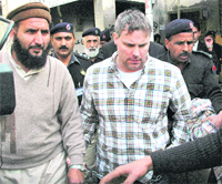 File photo of Raymond Davis being escorted by the police out of a Lahore court.