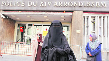 Nayet (C) in a burqa and Kenza Drider (L) in a niqab stand outside a police station in Paris soon after their release on Monday. France has become the first country in Europe to ban full face veils and will fine anyone in a niqab or burqa 150 euros. While a burqa covers the body from head to toe, a niqab is a veil that covers the face with just a slit for the eyes.