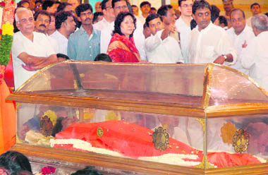 Devotees gather around the coffin of Sathya Sai Baba at Sai Kulwant Hall in Puttaparthi on Sunday. 
