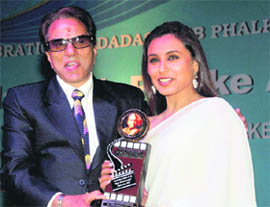 Bollywood actor Dharmendra presents an award to actress Rani Mukherjee at the Dadasaheb Phalke Academy Awards 2011 function in Mumbai.