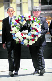 OBAMA AT GROUND ZERO: US President Barack Obama (L) carries a wreath along with a firefighter at the 9/11 Memorial at Ground Zero in New York on Thursday.