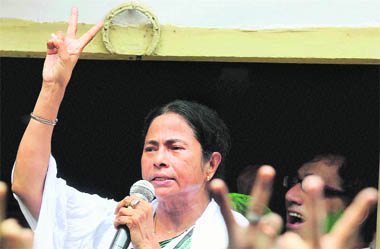 Trinamool Congress chief Mamata Banerjee flashes the victory sign in Kolkata
