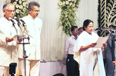 West Bengal Governor MK Narayanan administers the oath to Trinamool Congress chief Mamata Banerjee (R) as the West Bengal Chief Minister during the swearing-in ceremony at Governors House in Kolkata