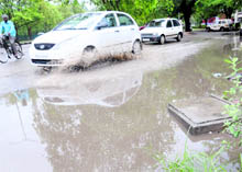 A car makes its way through a water-logged road at Piccadily Chowk in Chandigarh