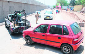 A recovery van tows away a car from the wrong side of the Zirakpur-Panchkula highway, on Sunday.