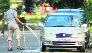A man washes a car at Sector 29 in Chandigarh.