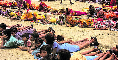 Children and women of Gobindpur village lie on the ground during a protest against Posco in Jagatsinghpur.