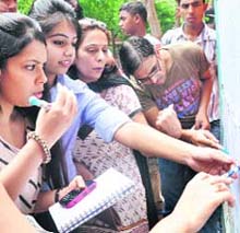 Anxious students see the first cut-off list at Delhi University in New Delhi on Wednesday.