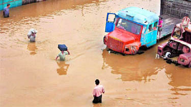 Residents wade through floodwaters after a heavy rain in Dimapur, Nagaland