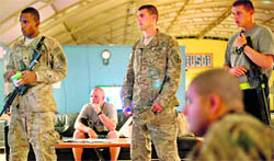 US soldiers watch a rebroadcast of President Barack Obama's speech on proposed troop withdrawal at Kandahar Airfield on Thursday.