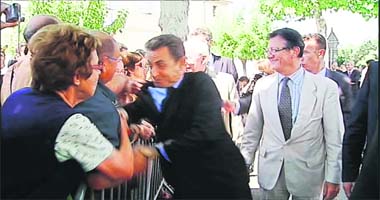 A TV grab shows a man grabbing French President Nicolas Sarkozy (C) by the jacket as he was greeting people gathered in Brax, southwestern France, on Thursday