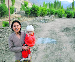 11 months after Leh cloudburst, scars still visible:  Stenzia Dolma shows the uncultivated fields in Nimmu village. 