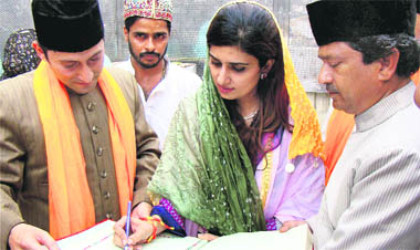 Pakistan's Foreign Minister Hina Rabbani Khar writes a message in the visitors register of the Anjuman Committee during her visit to the shrine of Khwaja Moinuddin Chishti in Ajmer 