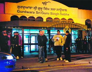 Sikhs gather outside the Sri Guru Singh Sabha Gurdwara in Southall, London, to protect the area from looters 
