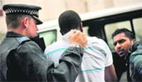 Metropolitan Police officers arrest a suspect after carrying out a raid on a property on the Churchill Gardens estate in Pimlico in London 