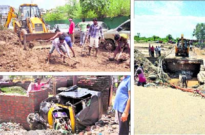 Officials of the PWD clear the Circular road in Jammu on Thursday; and (below) a damaged autorickshaw at Indira Colony in the Janipur area. Tribune photos: Inderjeet Singh