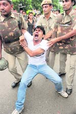 Security personnel detain a supporter of Anna Hazare in New Delhi.