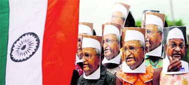 Supporters of veteran social activist Anna Hazare, wearing his masks, attend a protest against corruption in Agartala on Thursday.