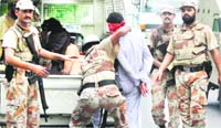 A paramilitary soldier detains a man during a house-to-house search operation in Karachi 