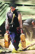 A Libyan rebel with boxes of ammunition found hidden underground . 