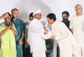 Union minister and former Maharashtra Chief Minister Vilasrao Deshmukh presents acceptance letter to Anna Hazare at Ramlila Maidan in New Delhi on Saturday