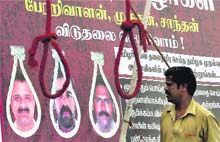 A man watching banner during a protest in Chennai demanding clemency for Perarivalan, Murugan and Santhan, the three convicts on death row